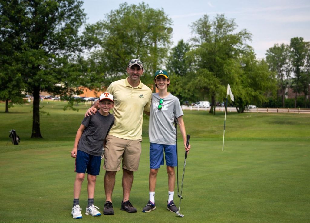 Father and two sons on the green