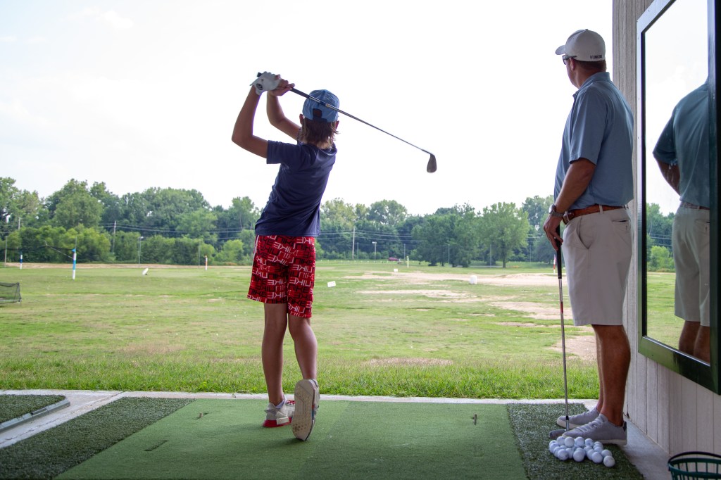 junior golfer at the driving range