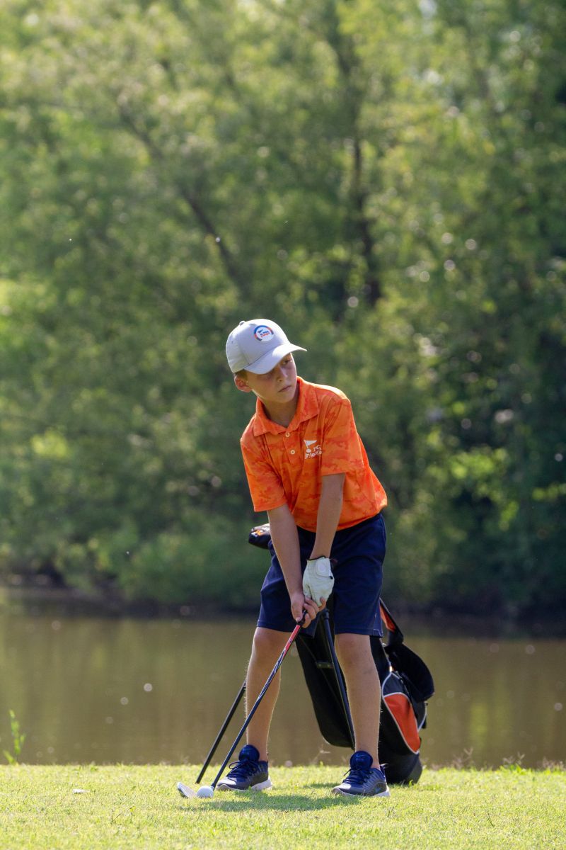 junior golfer lining up his shot