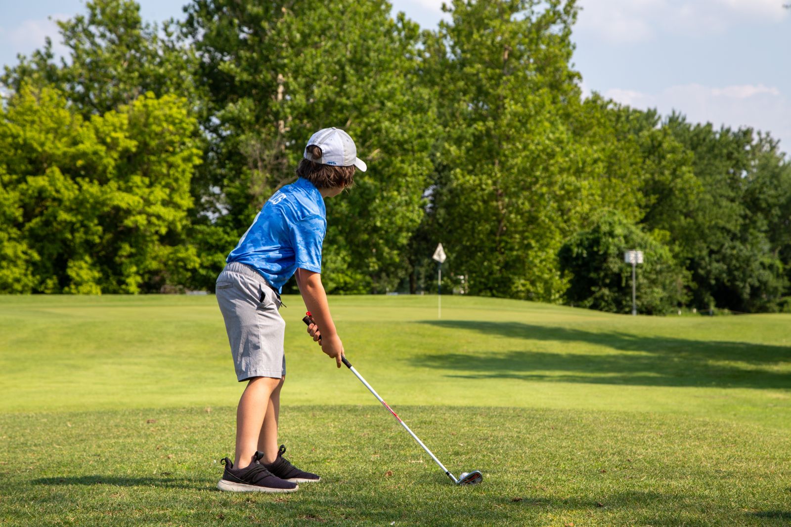 junior golfer teeing off